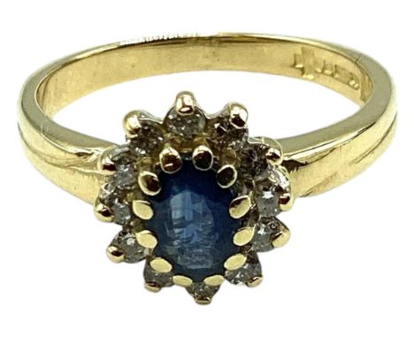A 18ct gold sapphire and diamond ring. Central oval free cut sapphire with a surround of 12 single cut diamonds. Size K. 3.3g
