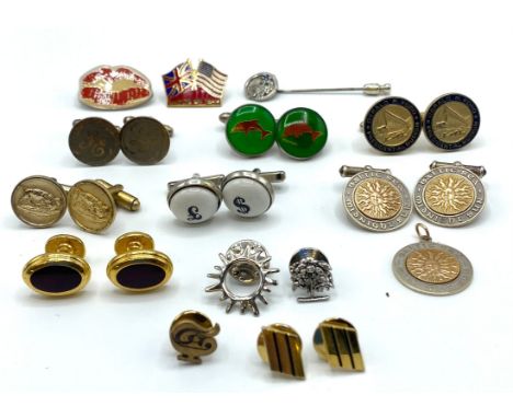 A collection of yellow and white metal cufflinks, tie pins and lapel badges together with a pair of white and yellow metal cu