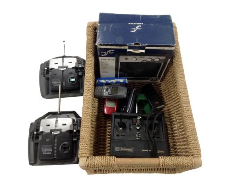 A basket containing a First Act practice amplifier, Futaba and Sanwa radio control handsets, assorted mobile phones.