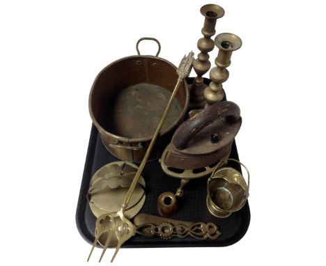 A tray containing antique and later brass and metalware including a trivet, a toasting fork, candlesticks, an antique copper 