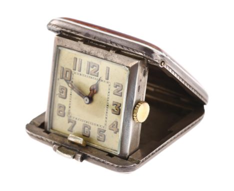 An Art Deco sterling silver and red enamel travelling bedside timepiece, square silvered dial with Arabic numerals, blued ste