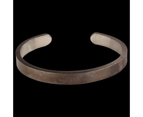 A late 20th century silver torque bangle, maker's marks RAA, hallmarks London 1981, band width 8mm, internal circumference 19