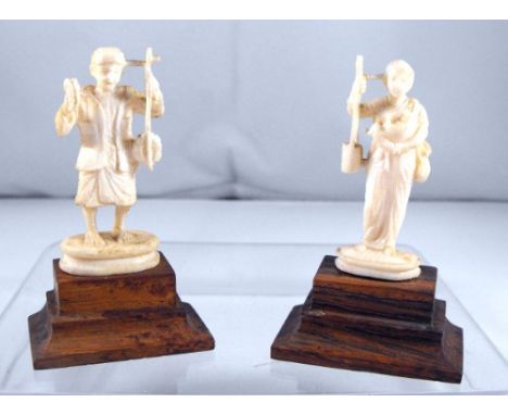 An Indian ivory figure of a tradesman mounted on a hardwood stand 6.5cm and another similar of a woman 6.5cm high (2) 