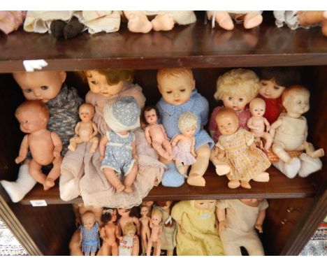 A collection of mid 20thC and later composite and plastic dolls, (contents of one shelf).