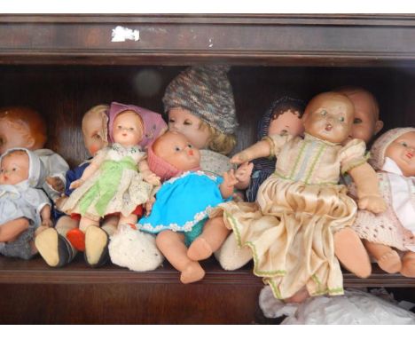 A collection of mid 20thC and later plastic and composite dolls, (contents of one shelf).