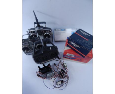 A collection of radio control operating handsets, an ABC Supersport Glow Engine, and a angular needle valve engine.