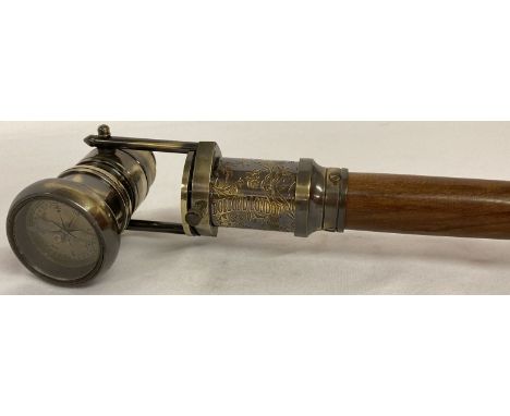 A reproduction wood and brass walking stick with swivel top telescope/compass handle.  Approx. 95.5cm long in folded position
