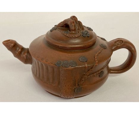 A small Chinese terracotta teapot with cherry blossom detail in relief. With shaped finial to lid and bamboo shaped spout. Im