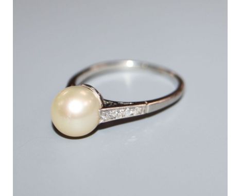 A white metal (stamped 'Plat') and cultured pearl dress ring with diamond set shoulders, size O/P.