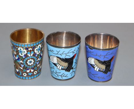 An early 20th century Russian 84 zolotnik and cloisonne enamel tot and two other white metal and enamel tots, tallest 48mm.