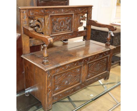 An 18th century style carved and panelled oak monk's bench W.100cm