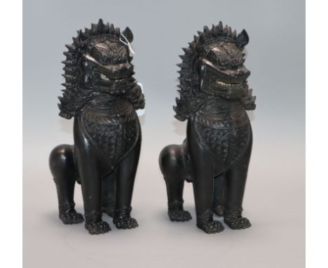 A pair of Thai bronze lion dogs height 27cm approx.