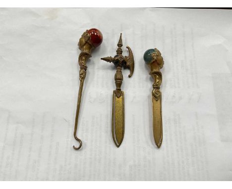 Victorian brass bookmark and button hook, the blackamoor handles set with agate stones, together with one other similar bookm