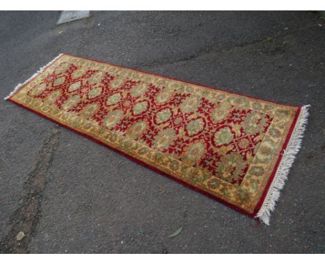 A 20TH CENTURY WOOLLEN RED CARPET RUNNER APPROX 232 X 76 CM