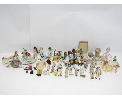 A collection of miniature bisque and glazed china dolls and doll heads, pin cushion dolls, three painted wooden miniature sai