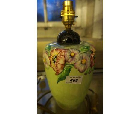 A Carltonware ceramic lamp base with relief moulded floral decoration based upon a lime green ground.