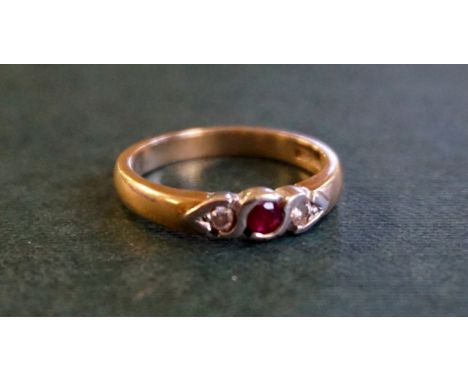 A 9ct yellow gold diamond and ruby three-stone ring.
