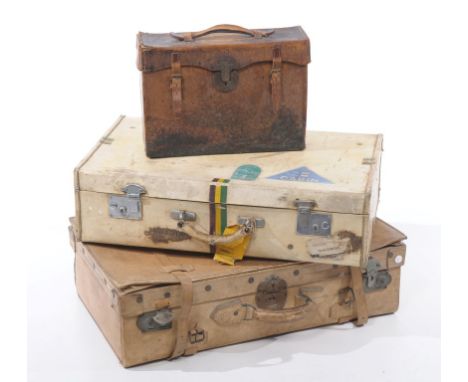 A group of three mid 20th Century vintage suitcases, to include a dyed cream pigskin example, attractively decorated with var
