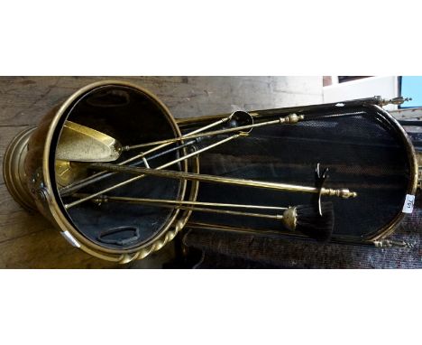 A vintage brass fireside suite, comprising a fire screen, companion set, coal bucket.