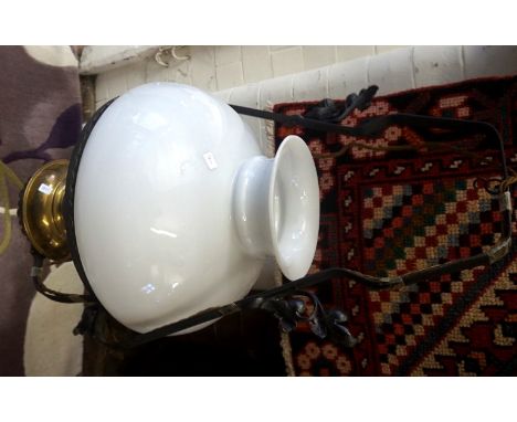 A mid 20th Century cast metal hanging paraffin lamp with milk glass shade (converted to electricity).