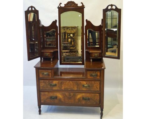 A good quality Edwardian walnut ladies dressing table, the central bevelled domed swing mirror with foliate carved cornice, f