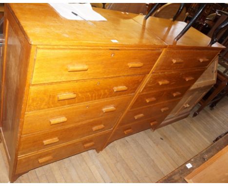 A pair of mid 20th Century light oak storage cabinets, having five drawers, with one being a pull down front. 