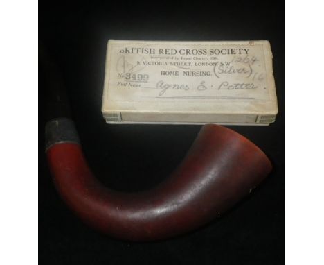 A collection of British Red Cross badges and a pipe