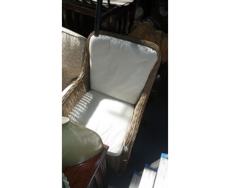 A contemporary wicker conservatory armchair, with loose cushions