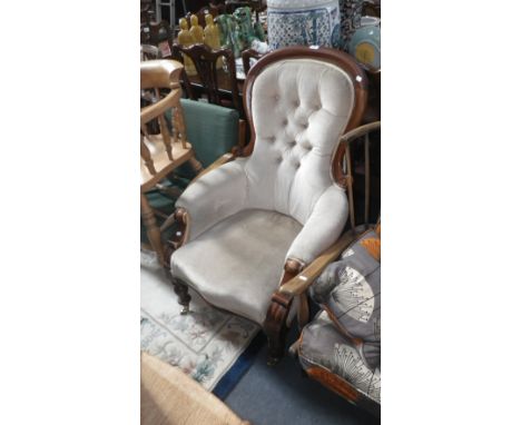 A Victorian walnut framed armchair, upholstered in cream velvet