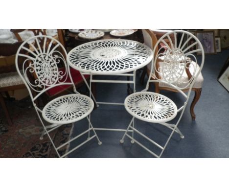 A Victorian style cream painted wrought-iron garden table and two chairs, table 27.5" dia