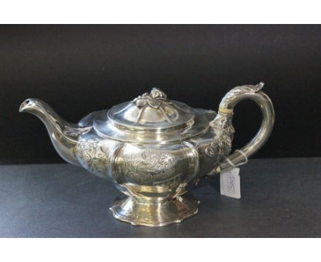 A silver William IV teapot decorated with flowers and garden life, with a flower finial and shaped pedestal base, London 1835