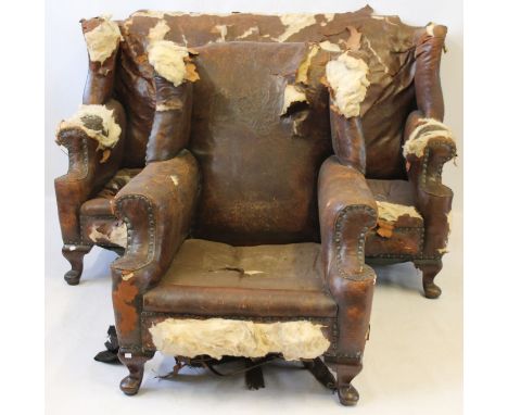 A period style wingback two-seater sofa and matching armchair, c.1900
The studded brown leather upholstery in need of complet