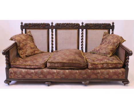 A Carolean Revival carved oak framed Bergere sofa, c.1920
The top rails carved with cherubs, crowns and scrolling foliage abo