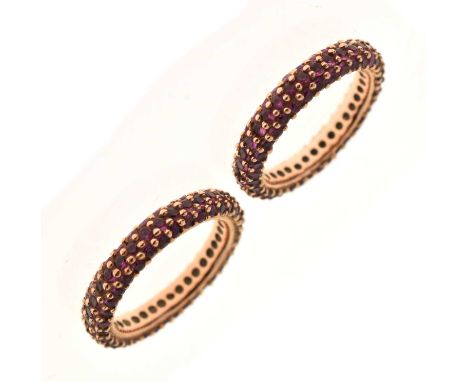 Pair of ruby pave set eternity rings, each stamped '18K 750 GA', sizes M and N, 8.5g gross approx (2)