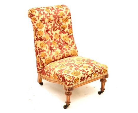 Victorian deep button back nursing chair having red and gold floral and foliate decoration, raised on two front carved turned