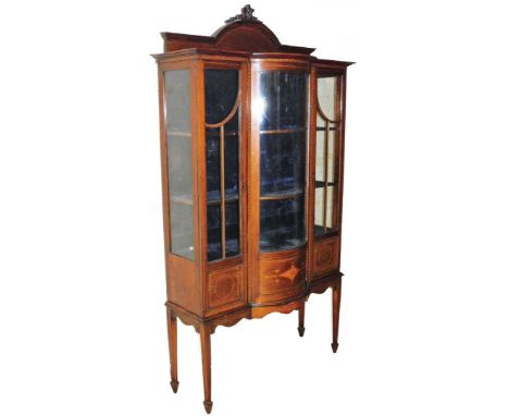 An Edwardian mahogany boxwood strung display cabinet, the arched corners surmounted by a ribbon and bell flower finial, raise