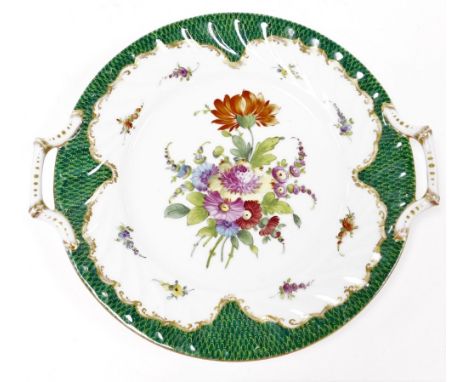 A Dresden centre plate, with central floral motif and gilt and green border decoration, with two handles, with Dresden blue s