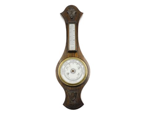 A 20thC mahogany aneroid barometer, the top with temperature dial, the base with ceramic circular dial, with carved motif pan