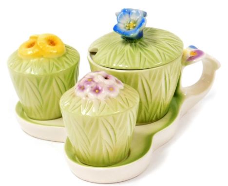 A Goebel trio cruet set, in overall green leaf design with blue, purple and yellow flowers, on a serving tray, with W blue Go