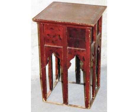 An early 20thC Japanese red lacquered stand, the square top with a shaped mother of pearl style inlay, raised on shaped stile