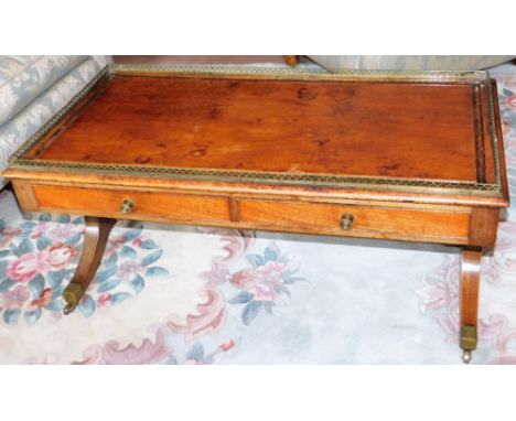 A late Regency mahogany sofa table, of reduced form, with a brass galleried top above two frieze drawers, raised on out swept