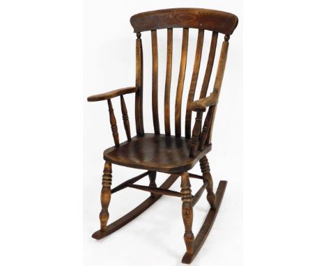 A early 19thC oak rocking chair, the shaped splat back on curved handles with bobbin turned legs, 115cm high, 60cm wide, 72cm