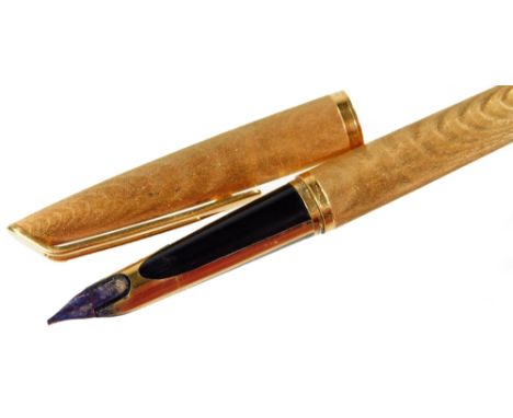 A Waterman's fountain pen, in engine turned gilt, with shaped clip and enclosed 18K nib, 13.5cm long.