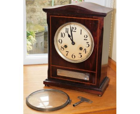 An early 20thC mahogany mantel clock, eight day movement, coil strike, with white enamel clock face and marquetry banded bord
