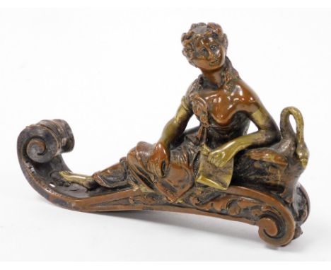 A neoclassical figure of a lady reclining on sofa, metal, 8cm high, 15.5cm wide.