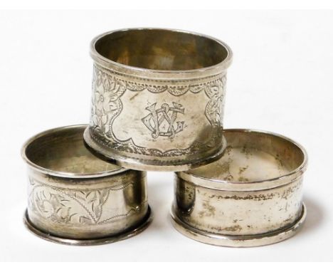 Three silver napkin rings, comprising a George V silver engine turned ring bearing foliate design and initials CS, Birmingham