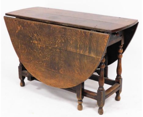 A late 19thC oak gateleg table, the two plank top with three plank flaps, on bobbin turned columns, with single frieze drawer