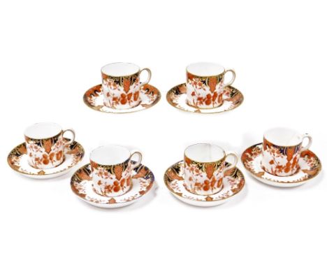 A set of six Royal Crown Derby coffee cans and saucers, each numbered 712, in the Imari style pattern with a blue and gilt ba