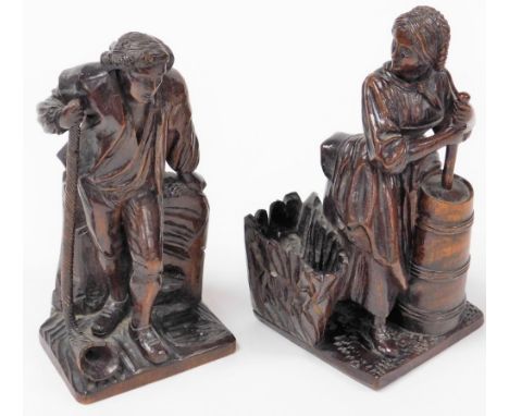 A pair of early 18thC continental walnut carvings, one depicting a gentleman with a long pipe, 22cm high, the other a lady ca