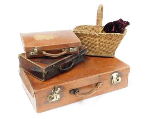 Three leather trunks and a wicker basket, the largest leather bound trunk with brass handle 66cm wide, 34cm deep, together wi